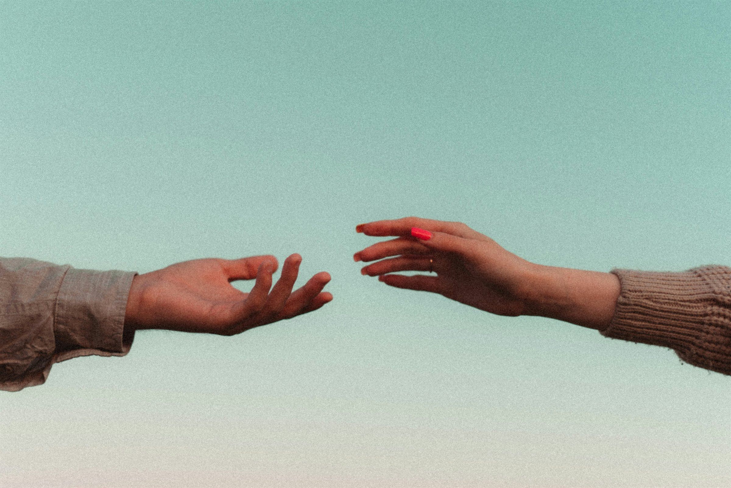 Deux mains qui se tendent l'une vers l'autre, symbole d'écoute et de partage